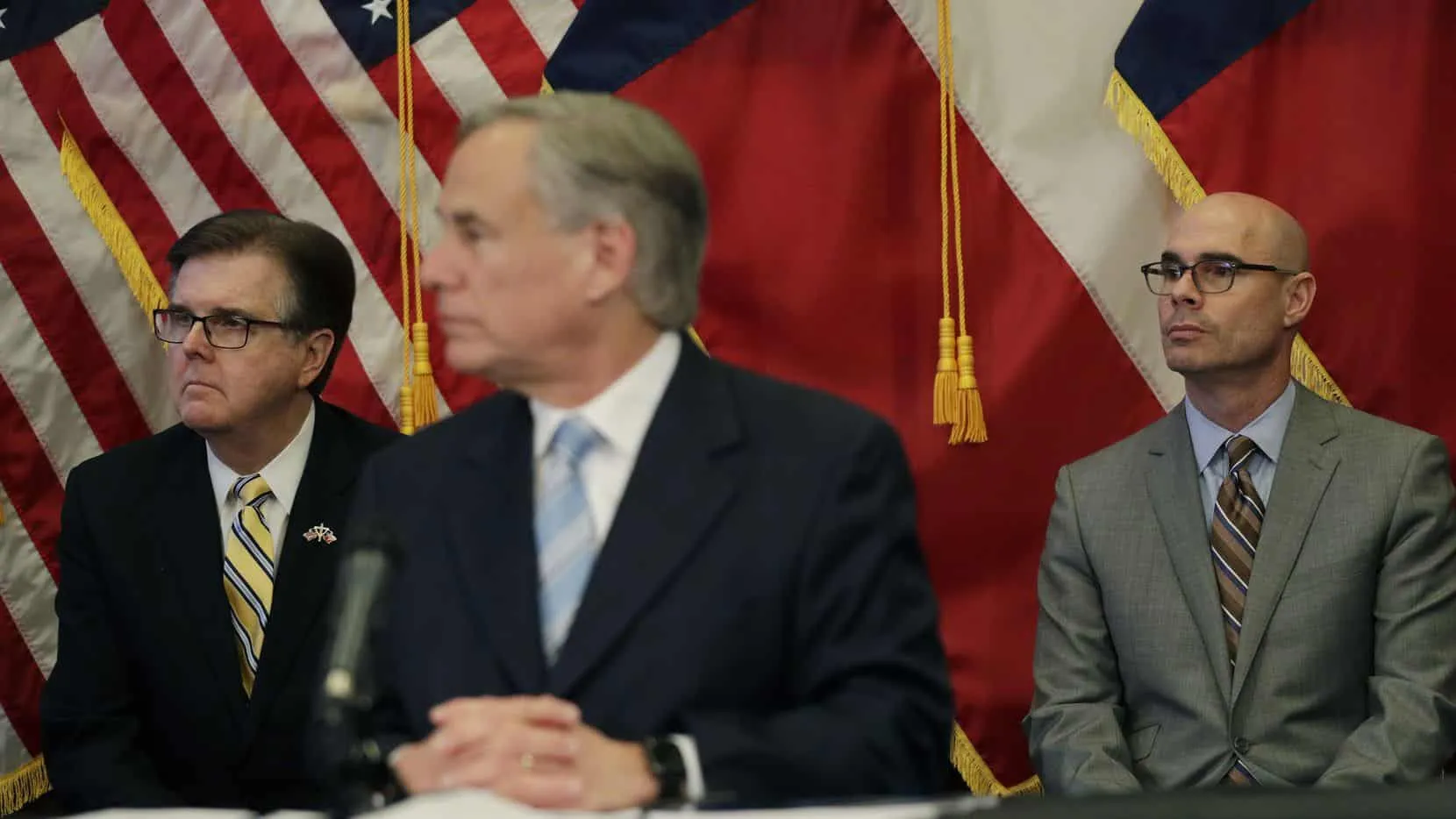 Lt. Gov. Dan Patrick, left, and Texas House Speaker Dennis Bonnen, right, sit behind Texas Gov. Greg Abbott, center, during a news conference where the governor announced he would relax some restrictions imposed on businesses due to the COVID-19 pandemic Monday, April 27, 2020, in Austin, Texas. (AP Photo/Eric Gay)(Eric Gay)