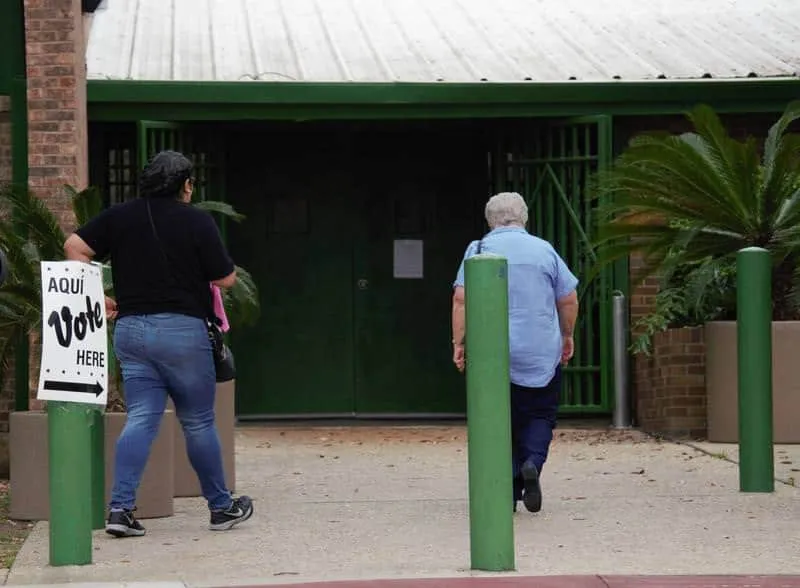 Two voters head into the polls for the Bexar County primary in March. LAUREN TERRAZAS | TEXAS PUBLIC RADIO